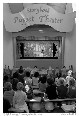 Children look at Snow white puppet show, Fairyland. Oakland, California, USA (black and white)