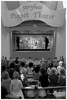 Children look at Snow white puppet show, Fairyland. Oakland, California, USA (black and white)