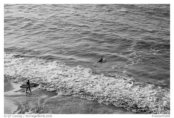 Surfers departing the beach towards the break. Half Moon Bay, California, USA