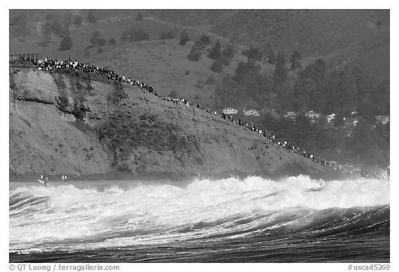 Bluff with spectators as seen from the ocean. Half Moon Bay, California, USA (black and white)