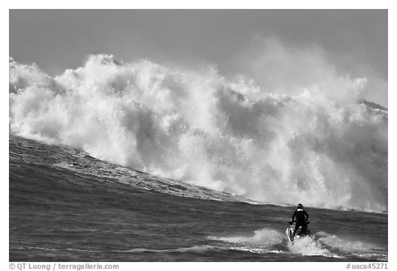 Jet ski dwarfed by huge breaking wave. Half Moon Bay, California, USA (black and white)