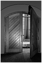 Wooden door opening to wine storage tanks. Napa Valley, California, USA (black and white)