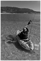 Sea kayaker with fishing rod in Carmel Bay. Carmel-by-the-Sea, California, USA ( black and white)