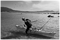 Man boards sea kayak, Carmel Bay. Carmel-by-the-Sea, California, USA (black and white)