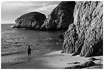 Boy standing at the base of bluff, China Cove. Point Lobos State Preserve, California, USA ( black and white)