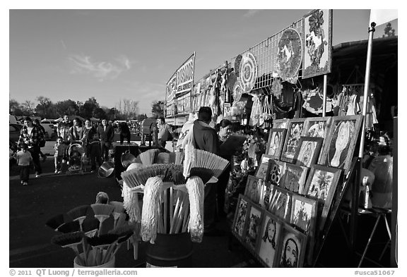 Brooms and religious pictures for sale, San Jose Flee Market. San Jose, California, USA