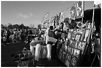 Brooms and religious pictures for sale, San Jose Flee Market. San Jose, California, USA (black and white)