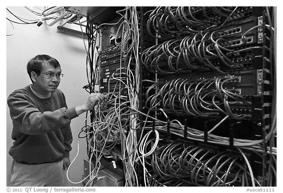 Technician rearranging data cables. Menlo Park,  California, USA (black and white)