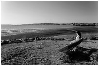 Woman sitting on bench, Carquinez Strait Regional Shoreline. Martinez, California, USA (black and white)