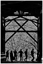 Silhouettes of people dancing inside covered bridge, Felton. California, USA ( black and white)