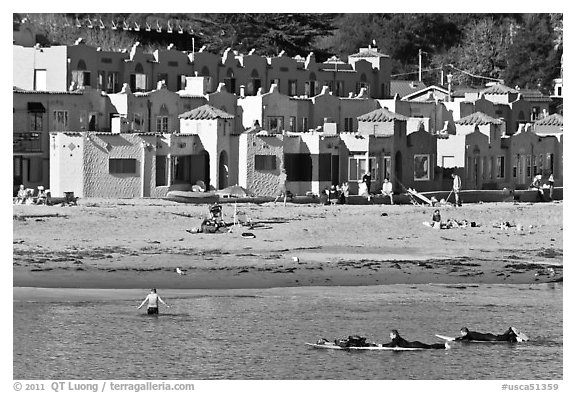 Surfers, beach, and Venetian hotel cottages. Capitola, California, USA