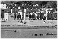 Surfers, beach, and Venetian hotel cottages. Capitola, California, USA (black and white)