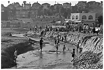 Children playing in tidal stream. Capitola, California, USA (black and white)