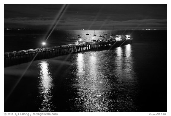 Wharf with moon reflections and light rays. Capitola, California, USA (black and white)