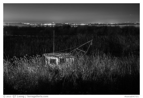 Fishing boat amongst tall grasses by night, Alviso. San Jose, California, USA (black and white)