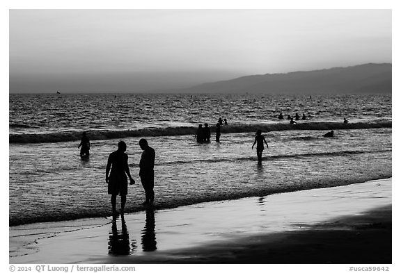 Sunset with beachgoers in water. Santa Monica, Los Angeles, California, USA (black and white)