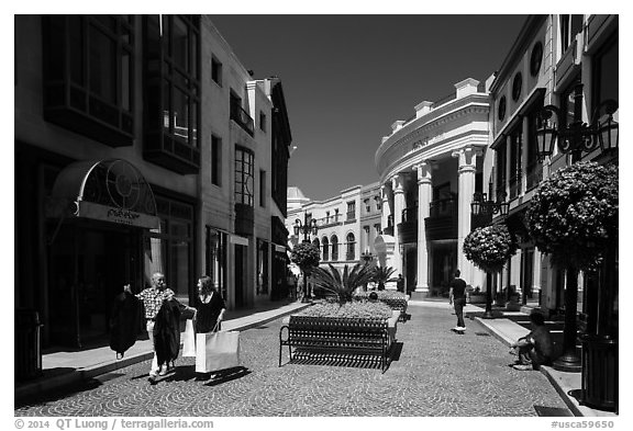 People carry garnments in  Rodeo Drive shopping district. Beverly Hills, Los Angeles, California, USA (black and white)
