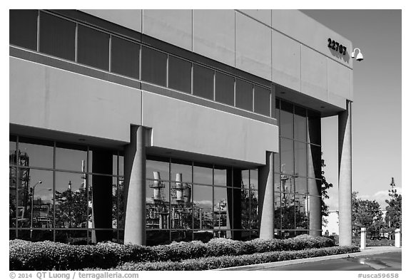 Oil refinery reflected in windows of office building, Manhattan Beach. Los Angeles, California, USA (black and white)