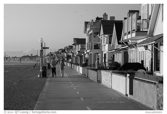 People exercising on beachfront walkway. Newport Beach, Orange County, California, USA (black and white)
