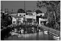 Rower under bridge next to colorful houses. Venice, Los Angeles, California, USA ( black and white)