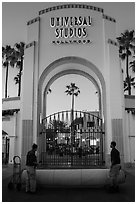 Men roll red carpet in front of Universal Studios gate. Universal City, Los Angeles, California, USA ( black and white)