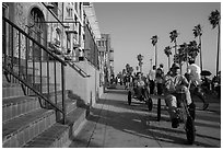 Men riding tricycles on Ocean Front Walk. Venice, Los Angeles, California, USA ( black and white)