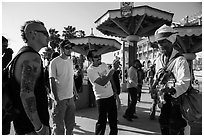 Tourists photograph Ocean Front Walk entertainer. Venice, Los Angeles, California, USA ( black and white)