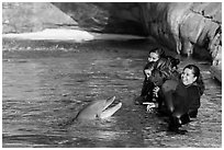 Guests interact with dolphin. SeaWorld San Diego, California, USA ( black and white)