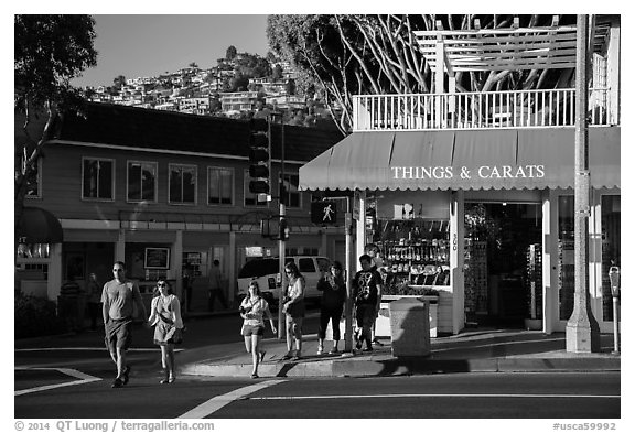 Visitors cross street in shopping area. Laguna Beach, Orange County, California, USA (black and white)