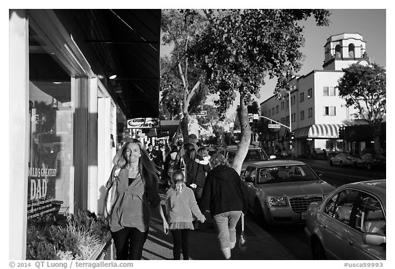Visitors walk on sidewalk in shopping area. Laguna Beach, Orange County, California, USA (black and white)