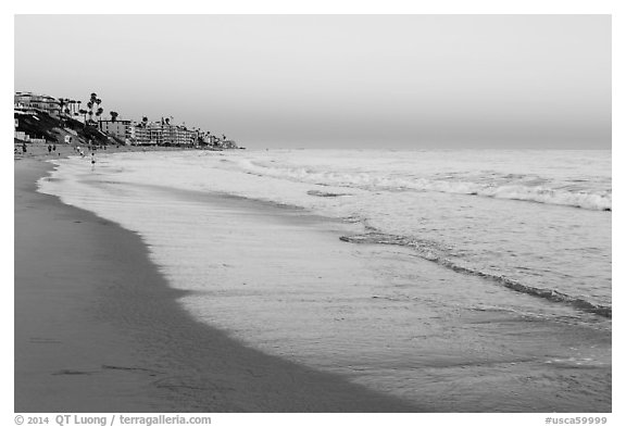 Beach at sunset with colors of sky reflected in wet sand. Laguna Beach, Orange County, California, USA (black and white)
