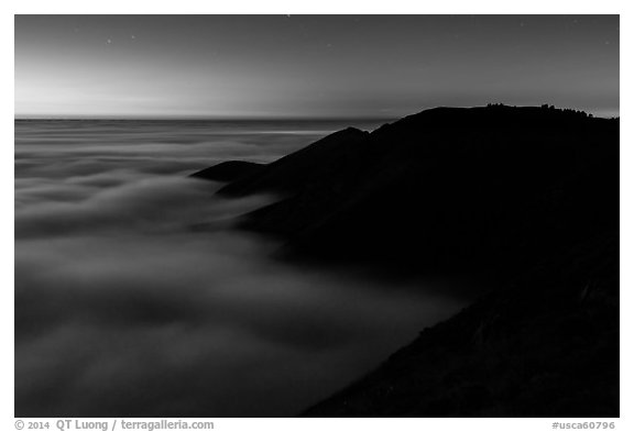 Hills emerging from sea of clouds at dusk, Garrapata State Park. Big Sur, California, USA (black and white)