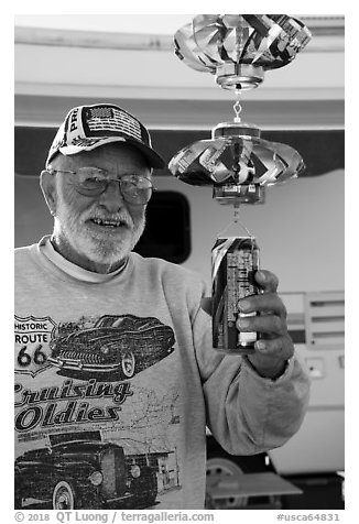 Man with mobile he made out of cans, Slab City. Nyland, California, USA (black and white)