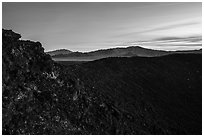Rim of Amboy Crater and mountains at dusk. Mojave Trails National Monument, California, USA ( black and white)