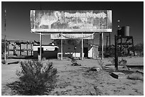 Old billboard and abandonned gas station. Mojave Trails National Monument, California, USA ( black and white)