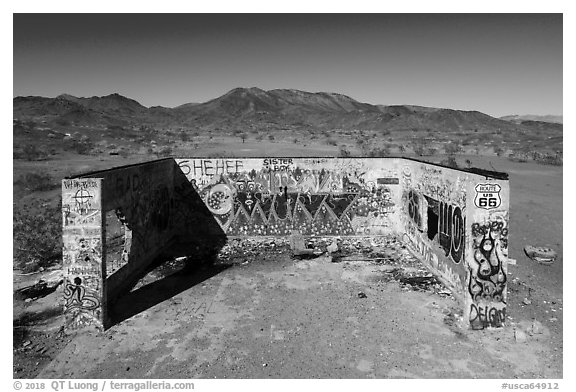 Aerial view of abandonned structure with graffiti and route 66 marker. Mojave Trails National Monument, California, USA (black and white)