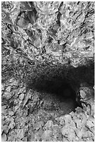 Hiker at entrance of Skull Cave. Lava Beds National Monument, California, USA ( black and white)