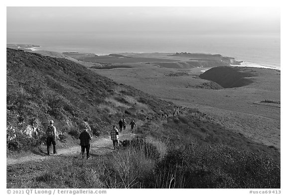 Group hiking above grassy marine coastal terrace. Cotoni-Coast Dairies Unit, California Coastal National Monument, California, USA