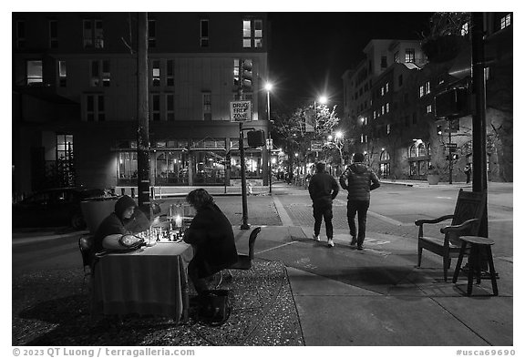 Men playing chess on Telegraph Avenue at night. Berkeley, California, USA