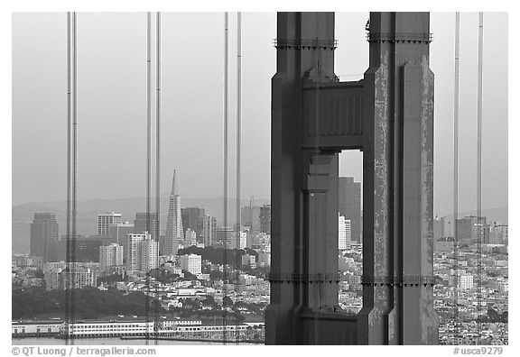 City through cables and pilars of Golden Gate bridge, dusk. San Francisco, California, USA (black and white)