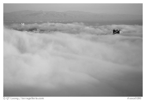 Pilar of the Golden Gate Bridge emerging from the fog at sunset. San Francisco, California, USA (black and white)