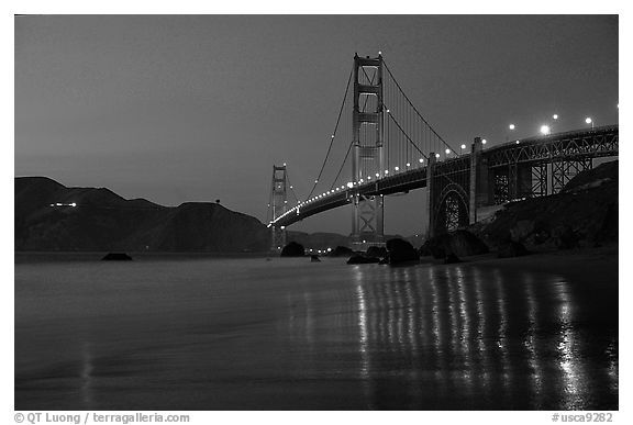 Golden Gate bridge and surf with light reflections, seen from E Baker Beach, dusk. San Francisco, California, USA