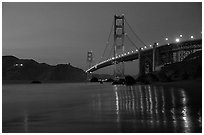 Golden Gate bridge and surf with light reflections, seen from E Baker Beach, dusk. San Francisco, California, USA (black and white)