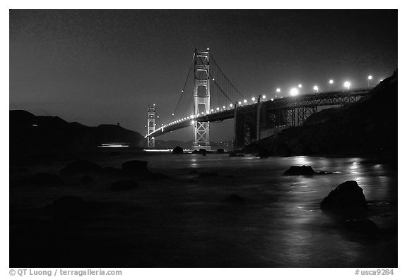 Golden Gate bridge and surf seen from E Baker Beach, night. San Francisco, California, USA (black and white)