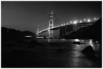 Golden Gate bridge and surf seen from E Baker Beach, night. San Francisco, California, USA (black and white)