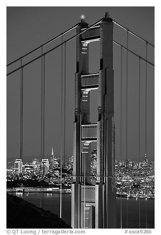 The city seen through the cables and pilars of the Golden Gate bridge, night. San Francisco, California, USA (black and white)