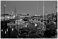 Fishing boat in Fisherman's Wharf, with Alioto's in the background, dusk. San Francisco, California, USA ( black and white)