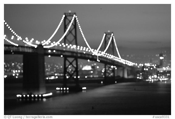 Bay Bridge seen from Treasure Island with defocused lights, sunset. San Francisco, California, USA (black and white)