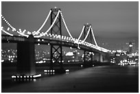 Bay Bridge seen from Treasure Island with defocused lights, sunset. San Francisco, California, USA (black and white)