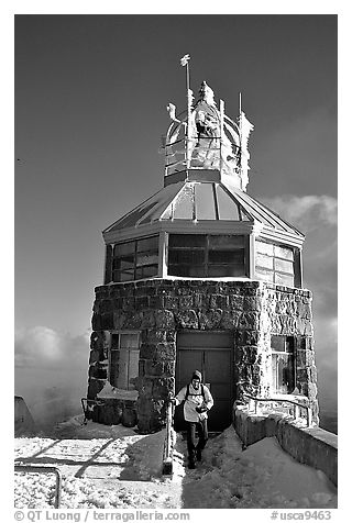 Hiker gets out of the ice-clad summit tower during a cold winter day, Mt Diablo State Park. California, USA (black and white)
